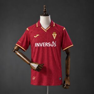 Camiseta Real Murcia 2026-2027 local grana con cuello polo y detalles dorados