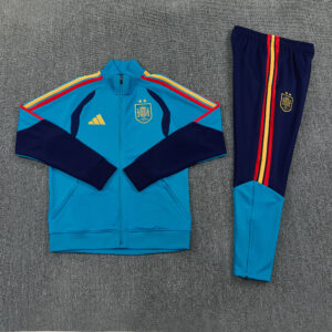 Chándal España 26/27 Essential extendido con chaqueta turquesa, detalles azul marino y pantalón largo con franjas rojas y amarillas